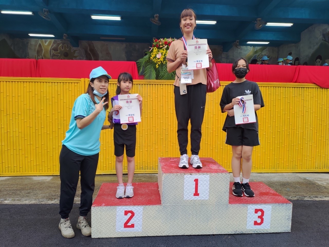 民政課課長頒發國小女子組100公尺得獎選手